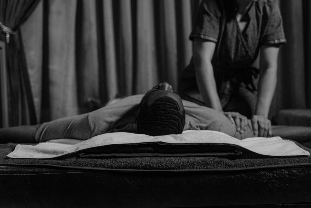 Grayscale Photo of a Woman Doing a Massage to a Man's Arm